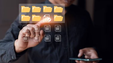 İşadamı belge kontrol listesi simgesine dokunuyor. Belge veritabanı dosyalarını ara ve yönet. Belge yönetim sistemi kavramı