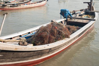 İskeledeki bir teknede balık ağı ve yosun yığını.