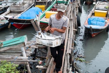 Lampung, Endonezya, 19 Mayıs 2023: Bir balıkçı yakaladığı balıkları sepette taşır