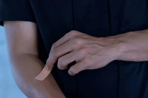 抽象的なライトブルーの背景に手に石膏を置く男 — ストック写真