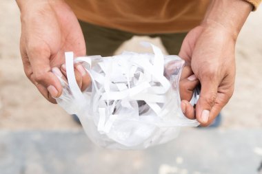Plastiğin içindeki bükülmüş karton insan ellerinde. Atık bulunmayan alışveriş