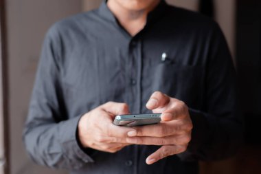 Akıllı telefon kullanan bir iş adamının elini kapat.