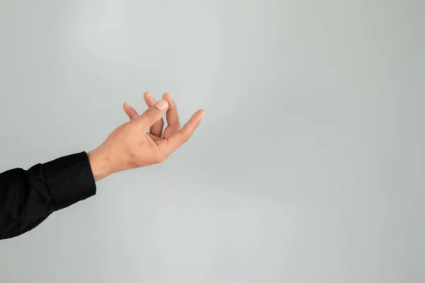 Asian young man hand snapping fingers to reach, reaching symbol gesture