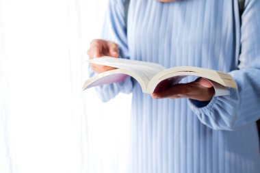 Beyaz arkaplan üzerine kitap okuyan kadının ön görüntüsü, kapat