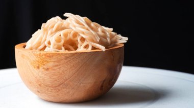 Masadaki siyah bir zemine izole edilmiş karides cipsleri, genellikle yan yemek olarak sunulan geleneksel bir Endonezya atıştırmalığı.