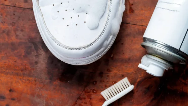 Leather white sneakers with care kit. Leather footwear care concept