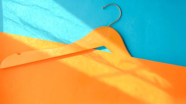Άδεια Ξύλινη Κρεμάστρα Ρούχων Παστέλ Πορτοκαλί Και Μπλε Φόντο Στο — Φωτογραφία Αρχείου
