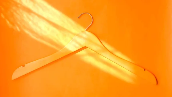 Άδεια Ξύλινη Κρεμάστρα Ρούχων Παστέλ Πορτοκαλί Φόντο Στο Φως Του — Φωτογραφία Αρχείου