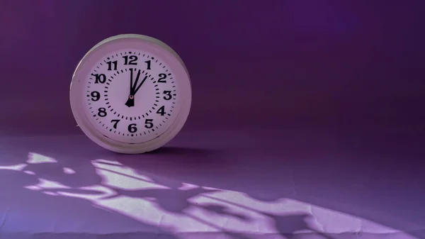 影と紫色の背景に白い丸時計 製品表示 — ストック写真