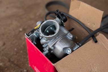 Bir paket kutusunda motosiklet karbüratörü.