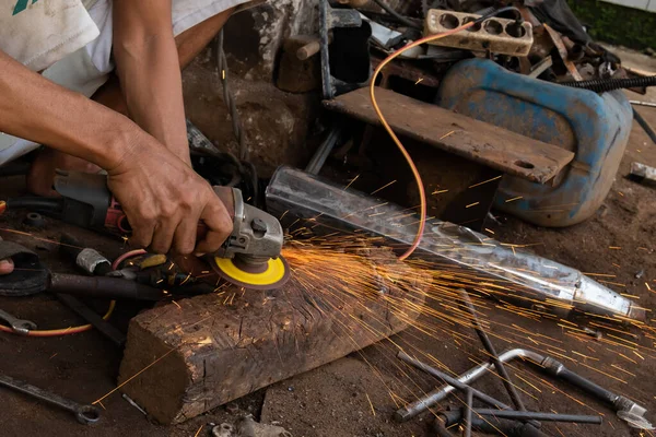 stock image A welder cutting metal with a grinder prepares to weld