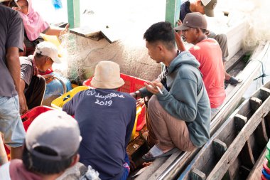 Lampung, Endonezya, 17 Haziran 2023: Sepet içinde balık sıralayan balıkçılar. Endonezya 'daki balık müzayedesinde satılık taze balık sepetleri içinde taze balık.