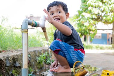 Çeşmede oynayan çocuklar musluk suyundan
