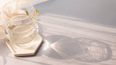 Masada güneş ışınlarının yansıması olan cam bardak. minimalist kavram