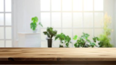 Bulanık oturma odası arka planında boş ahşap masa. Boş alan, montaj, ürün ve reklam tasarımları için kullanılabilir