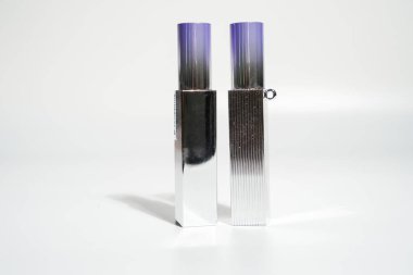 Beyaz arka planda renkleri değişen iki makyaj tüpü.