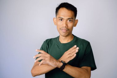 Açık gri bir arka planda kolları katlanmış bir kişinin portresi