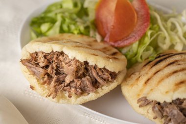 Arepas 'a yakın, tipik Venezuela yemekleri, mısır ve öğütülmüş etle yapılır..