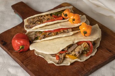 Taco, tipik Meksika yemeği, biftek, sebze ve ahşap bir tahtada kırmızı biber..