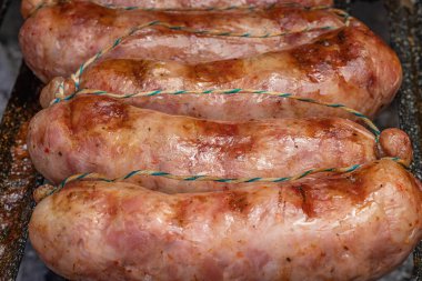 Close up of grilled chorizos on a cuting board , typical Argentine sausages made with mixed pork and beef meat.