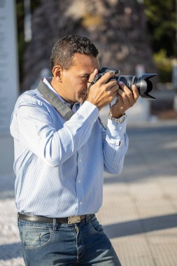 Latin fotoğrafçı sokakta fotoğraf çekiyor..