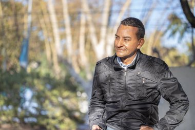 Kare bir bankta oturan ve fotokopi çeken genç latin adam..