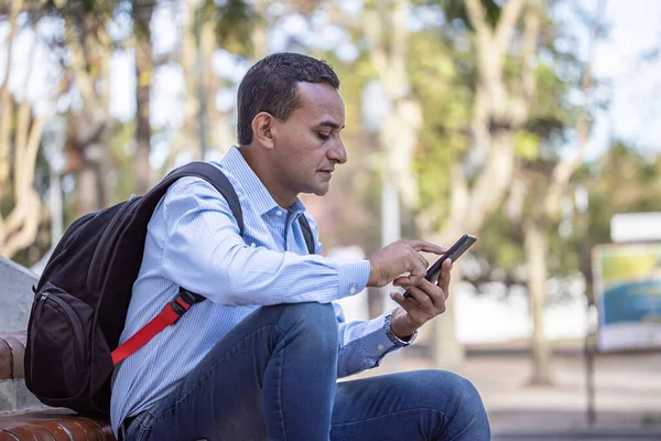 Mladý Latino Muž Sedí Schodech Dívá Svůj Mobilní Telefon — Stock fotografie