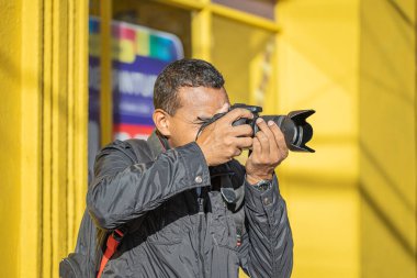 Latin fotoğrafçı kamerasıyla fotoğraf çekiyor..