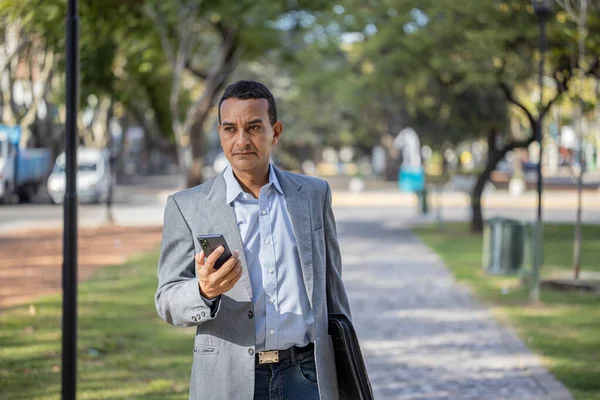Mladý Latinský Muž Obleku Chůze Mobilním Telefonem Ruce — Stock fotografie