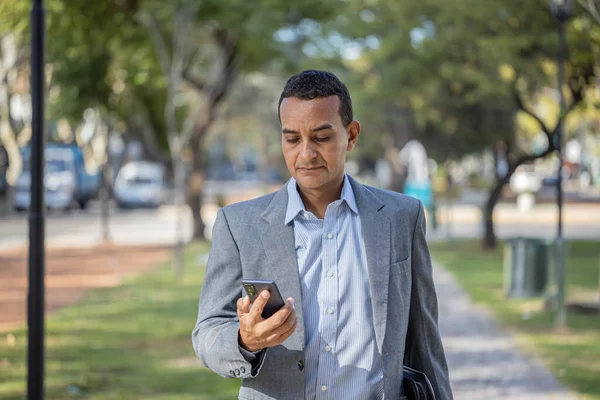 Mladý Latinský Muž Obleku Chůze Mobilním Telefonem Ruce Kopírovacím Prostorem — Stock fotografie