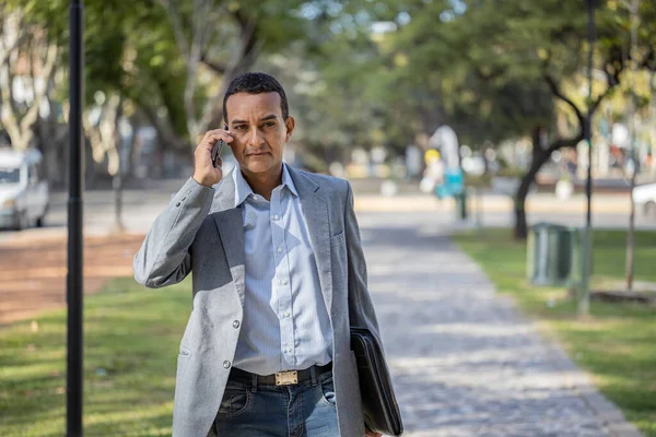 Mladý Latinský Muž Obleku Chůze Mluvení Mobilním Telefonu Kopírovacím Prostorem — Stock fotografie