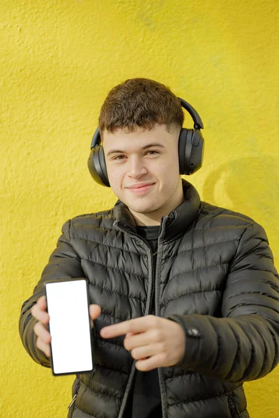 Ragazzo Caucasico Con Cuffie Mostra Schermo Vuoto Del Suo Telefono — Foto Stock