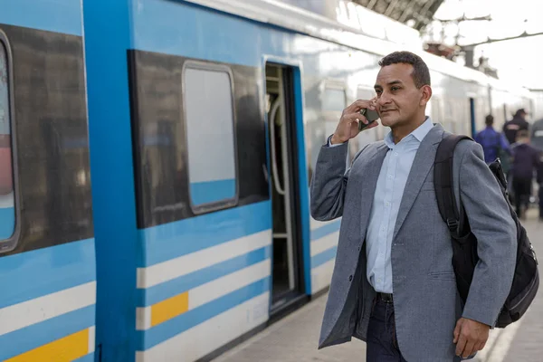 Latinský Muž Obleku Čeká Vlak Mluví Mobilním Telefonu — Stock fotografie
