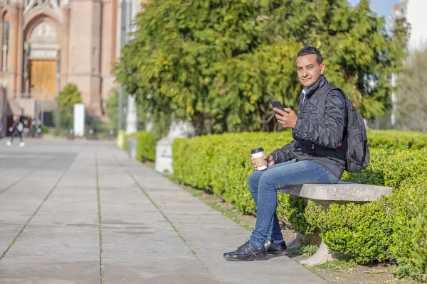 Mladý Latino Muž Sedí Lavičce Veřejném Parku Pomocí Svého Mobilního — Stock fotografie