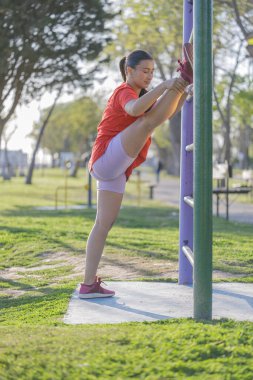 Latin kız halka açık bir parkta bacak esnetiyor..