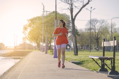 Latin kız şafakta nehir kıyısında koşuyor..