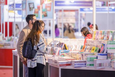 Buenos Aires, Arjantin; 26 Nisan 2024: Buenos Aires kitap fuarında kitap okuyan genç bir çift.