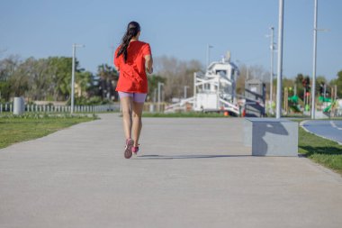 Spor giyinen Latin bir kız, arkadan görülmüş..