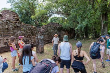 San Ignacio, Misiones, Arjantin - 5 Mayıs 2025: Bir grup turistle birlikte San Ignacio harabelerinde tur rehberliği.