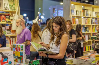 Buenos Aires, Arjantin - 2 Nisan 2025: Buenos Aires kitap fuarında okuyan genç kadın.