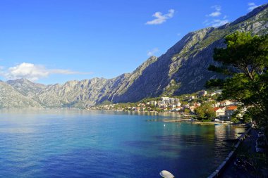 Adriyatik Denizi kıyısında inşa edilen Dobrota kasabası ve arkasındaki görkemli Kotor Dağları - St. Matthew Kilisesi 'nden (Karadağ) manzara).