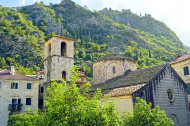 Kotor 'lu Ozana' nın kalıntılarının tutulduğu Nehir Aziz Mary Kilisesi - güneşli bir günde dağların zeminine karşı tapınağın manzarası (Kotor, Karadağ))       