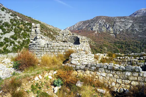 Kule ve diğer antik binaların kalıntıları açık ve güneşli bir günde dağların arka planına karşı. Risan kasabasının yukarısındaki Gradine Tepesi (Karadağ).            