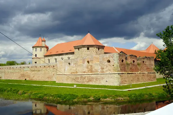 Fagaras kalesi ve önündeki hendek fırtınalı bir gökyüzünün arkaplanına karşı (Brasov County, Romanya)