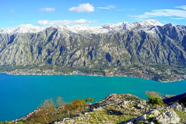 Karadağ 'ın Vrmac Dağı' ndan Kotor Körfezi: yüksek karlı dağların tepesinden nefes kesici manzaralar, kıyıdaki küçük yerleşim yerleri ve Adriyatik Denizi 'nin açık mavi suları.