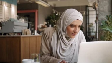 Serbest çalışan, eğitim gören, Webinar izleyen, video sohbeti yapan orta yaşlı Müslüman kadın. Ofis dışı iş, bağımsızlık, din, çeşitlilik, eşitlik kavramı