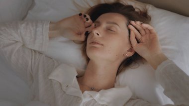 Tembel bir hafta sonu. Zarif pijamalı, uykulu, beyaz bir kadın uyanıyor. Yastığı açıyor, gülümsüyor ve yatakta geriniyor. Yeni gün tebrikleri ve sabah erkenden konforlu dairede eğlenmek.