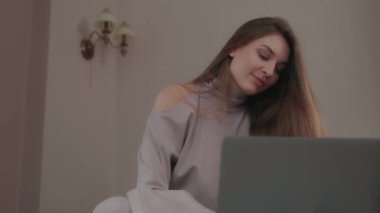 Genç iş kadını görüntülü arama ile iletişim kuruyor. Evde dizüstü bilgisayar üzerinde çalışırken yeni bir proje geliştiren kadın girişimci, çevrimiçi konferans, uzaktan çalışma, sanal eğitim konsepti