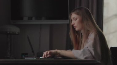 Genç iş kadını görüntülü arama ile iletişim kuruyor. Evde dizüstü bilgisayar üzerinde çalışırken yeni bir proje geliştiren kadın girişimci, çevrimiçi konferans, uzaktan çalışma, sanal eğitim konsepti