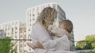 Anne ve kızı kucaklaşıyorlar, sevgi ve bağ kuruyorlar. Aile değerleri, bakım, birlikte iyi vakit geçirmek, mutluluk ve kasabanın arka bahçesinde eğlenmek